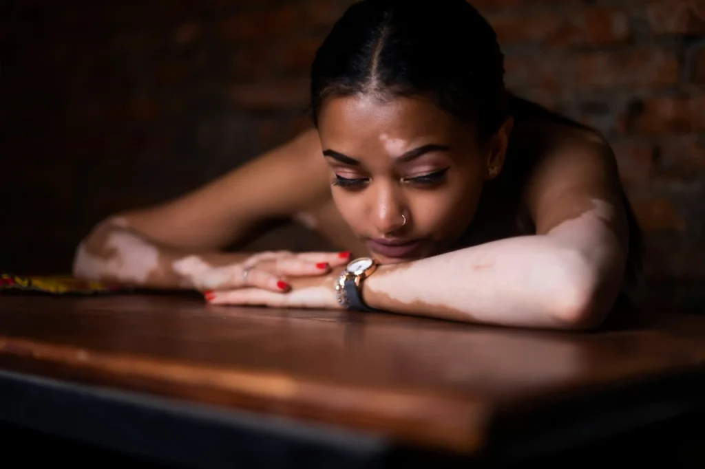 Young woman sitting at a table looking bored, illustrating the challenge of finding activities during early sobriety